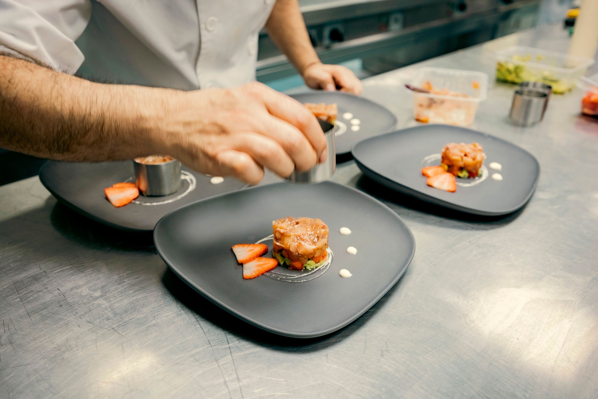 Chef plating gourmet dish in a professional kitchen