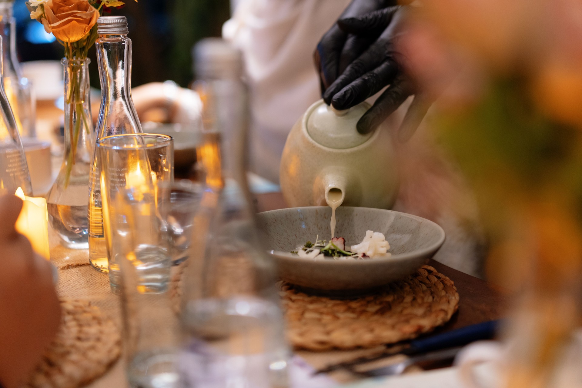 Chef's Hands Pouring Soup Over a Gourmet Dish